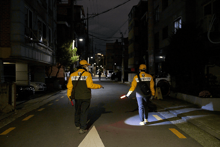 안심마을보안관 두 명이 주택가 골목을 순찰하고 있다